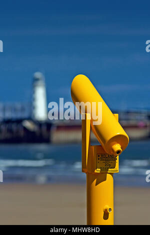 Ein leuchtendes Gelb anzeigen Teleskop in der South Bay Scarborough, vor dem Hintergrund der Hafen der Stadt und den Leuchtturm. Stockfoto