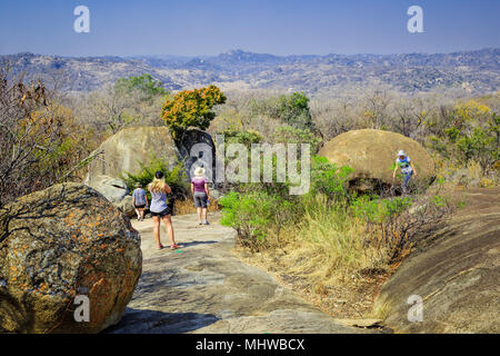 Touristen zu Fuß zwischen den Felsen im Matobo Nationalpark, Simbabwe. Stockfoto