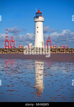 Ein Porträt von Barsch Rock Leuchtturm, über das Meer Verteidigung von New Brighton suchen, mit dem roten Krane von Liverpool Docks im Hintergrund Stockfoto