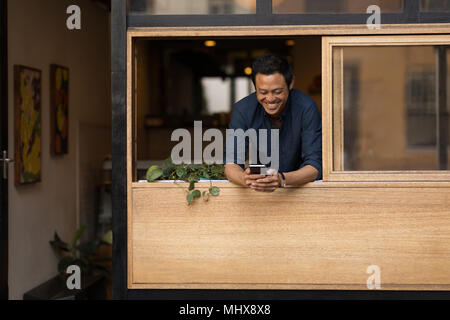 Geschäftsmann mit Mobiltelefon im Cafe Stockfoto