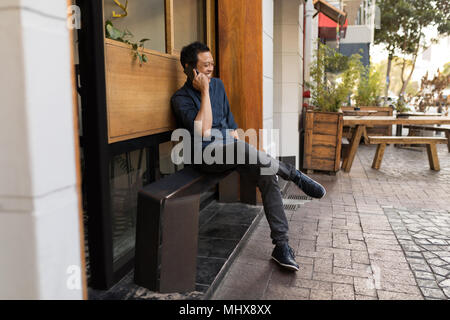 Geschäftsmann am Telefon sprechen im Straßencafé Stockfoto