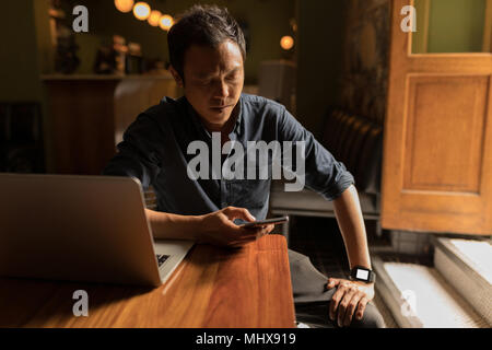 Geschäftsmann mit Mobiltelefon im Cafe Stockfoto