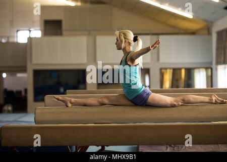 Weibliche athletische Balancieren auf Bar aus Holz Stockfoto