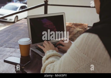 Urban hijab Frau mit Laptop im Straßencafé Stockfoto