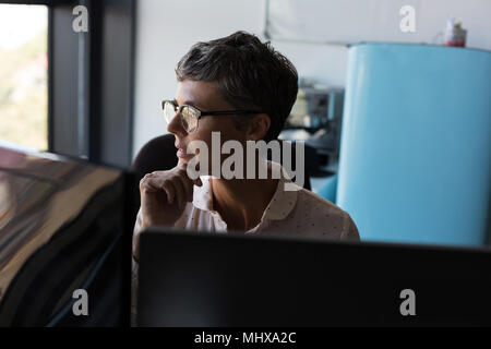 Reife Geschäftsfrau weg schauen im Büro Stockfoto