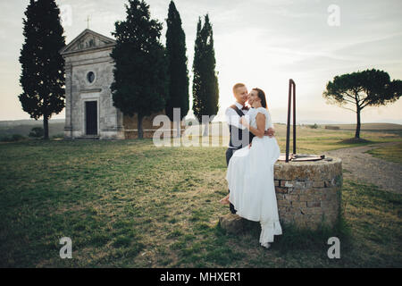 Gerne stilvolle lächelndes Paar und Küssen in der Toskana, Italien, am Tag ihrer Hochzeit. Stockfoto