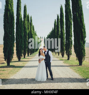 Gerne stilvolle lächelndes Paar und Küssen in der Toskana, Italien, am Tag ihrer Hochzeit. Stockfoto