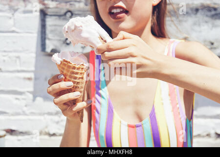 Junge Frau mit zwei schmelzenden Eis Kegel, 7/8 Stockfoto