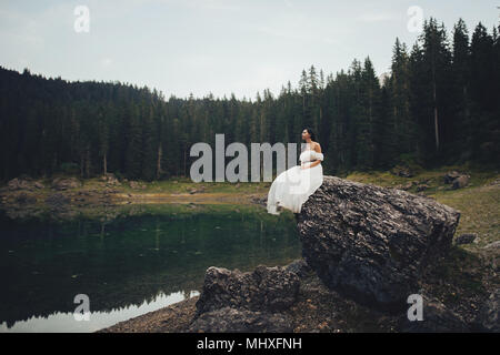 Junge Frau Entspannung auf See in den italienischen Alpen Stockfoto
