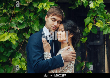 Portrait von eleganten asiatische Braut Bräutigam umarmen Stockfoto