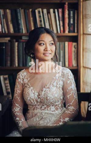 Lächelnd asiatische Braut in vintage Innenraum posing Stockfoto