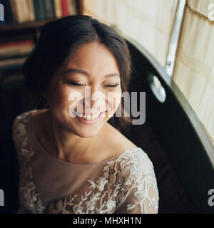Lächelnd asiatische Braut in vintage Innenraum posing Stockfoto