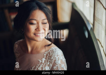 Lächelnd asiatische Braut in vintage Innenraum posing Stockfoto