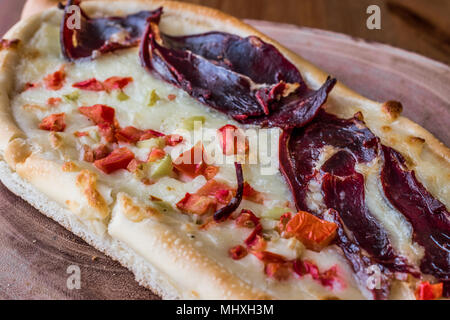 Türkischen Pide mit Pastirma, Tomate und geschmolzenem Käse auf einem Holz- Oberfläche. Stockfoto