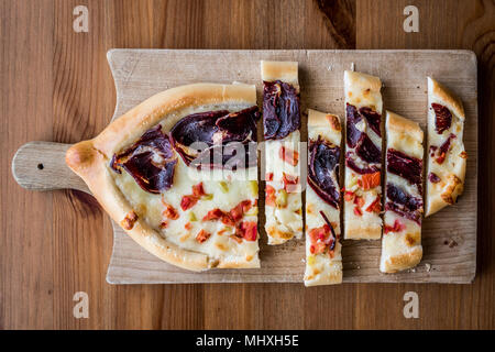 Türkischen Pide mit Pastirma, Tomate und geschmolzenem Käse auf einem Holz- Oberfläche. Stockfoto