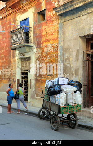 Zwei Frauen sprechen neben drei Rad Fahrrad mit Taschen von Recycling Dosen und anderen Abfällen, Havanna, Kuba Stockfoto
