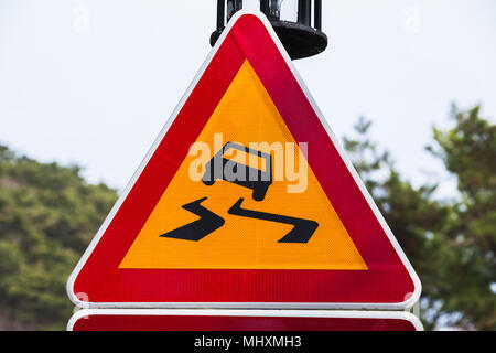 Rutschige Straße, Warndreieck Schild, die über helle Himmel Hintergrund Stockfoto