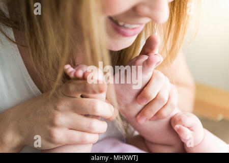 Mutter halten Babys Füße Stockfoto