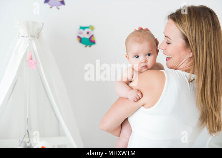 Mutter und Baby im Kinderzimmer Stockfoto