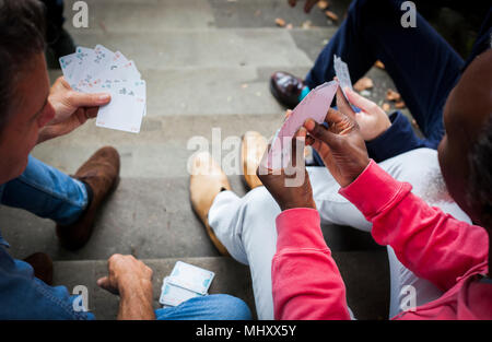 Drei reife Männer, draussen, sitzen auf Schritte, Karten spielen, Erhöhte Ansicht Stockfoto