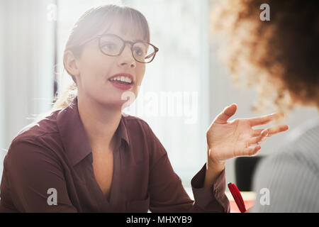 Im Büro Geschäftsfrau im Gespräch mit Kollegen Stockfoto