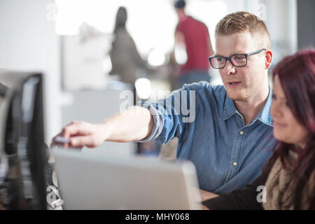 Männlichen und weiblichen Kollegen am Computer im Büro arbeiten Stockfoto