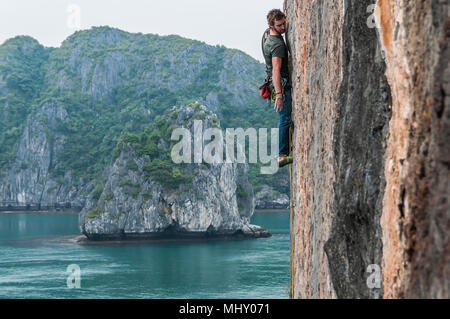 Man Klettern auf Kalkfelsen, Ha Long Bay, Vietnam
