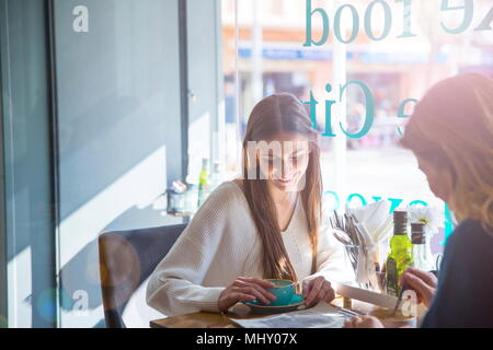 Zwei weibliche Freunde sitzen zusammen im Café, Kaffee trinken Stockfoto