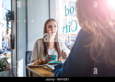 Zwei weibliche Freunde sitzen zusammen im Café, Kaffee trinken Stockfoto