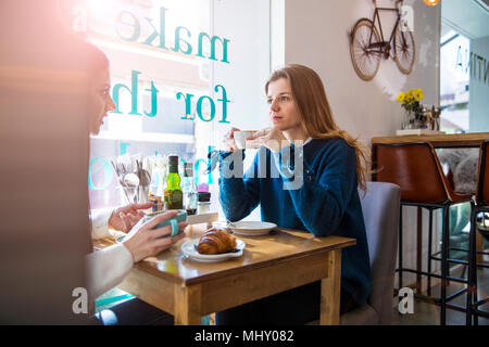 Zwei weibliche Freunde sitzen zusammen im Café, Kaffee trinken Stockfoto