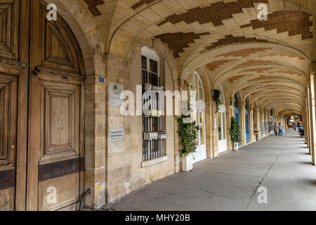 Unter den Bögen der Place des Vosges im Marais-Viertel von Paris, eine der schönsten Platz in der französischen Hauptstadt. Stockfoto