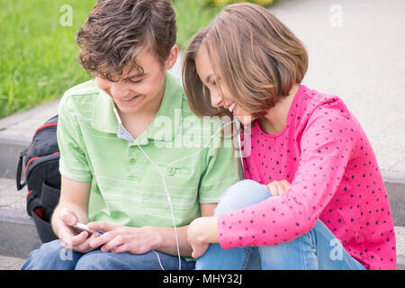 Teen Junge und Mädchen mit Kopfhörern Stockfoto