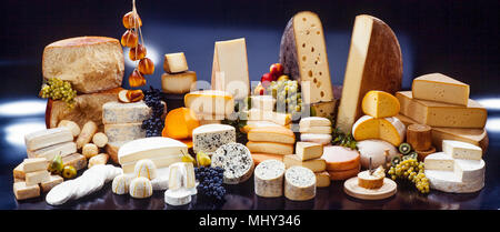 Große Auswahl an internationalen Käsespezialitäten auf schwarzem Hintergrund Stockfoto