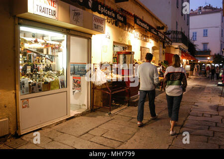 Touristen in einer schmalen Straße, die Rue Georges Clemenceau in der alten Stadt, Calvi auf Korsika, einer französischen Insel vor der Südküste von Frankreich im Mediterranea Stockfoto