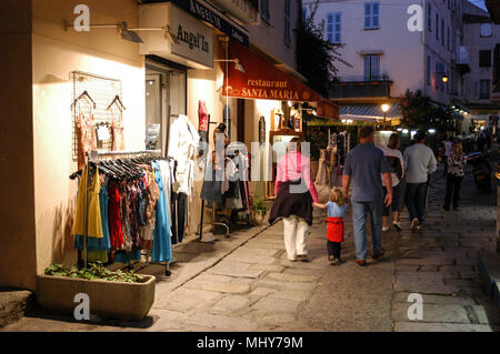 Touristen, die auf der Suche an einem Baugruppenträger oat ein Geschenk Shop in einer schmalen Straße, die Rue Georges Clemenceau in der alten Stadt, Calvi auf Korsika, einer französischen Insel im Sou Stockfoto