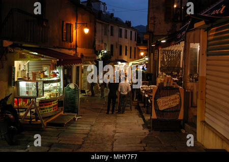 Touristen in einer schmalen Straße, die Rue Georges Clemenceau in der alten Stadt, Calvi auf Korsika, einer französischen Insel vor der Südküste Frankreichs im Mittelmeer Stockfoto