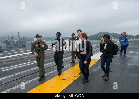 180503-N-CL 027-0076 Yokosuka, Japan (3. Mai 2018) Matrosen an Bord der Marine vorwärts - bereitgestellt Flugzeugträger USS Ronald Reagan (CVN 76), erklärt Flight Deck Operationen an der Northwestern University Medien Studenten während einer Schiffstour, 3. Mai 2018. Während der Tour, die Schülerinnen und Schüler besuchten verschiedene Stellen auf dem ganzen Schiff einschließlich der Flight Deck, hangar Bucht und der Brücke. Ronald Reagan, das Flaggschiff der Carrier Strike Group 5, bietet eine Bekämpfung bereit, Kraft, schützt und verteidigt die kollektive maritime Interessen seiner Verbündeten und Partnern in der indopazifischen Region. (U.S. Marine Foto von Masse Kom Stockfoto