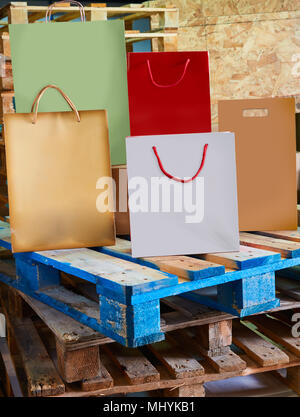 Säcke aus Papier Fabrik bunten auf Holzpalette Hintergrund Stockfoto