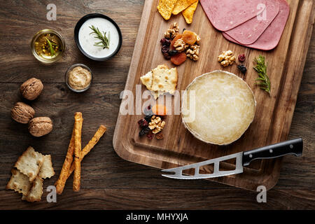 Türkische Karaman skinbag Käse (divle obruk) auf einem Holztisch mit Requisiten aus Holz Schneidebrett, Käsemesser und Walnüssen dekoriert Stockfoto