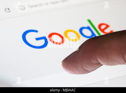 Finger zu geben Sie eine Suche auf der Google Suchmaschine Website. Stockfoto