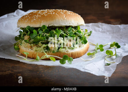 Eine vegetarische Burger aus einer Gluten-freien Brötchen mit Kichererbsen, Avocado und Kräuter, Radieschen Sprossen. Ein schnelles und gesundes Mittagessen Idee, von der sie glauben, dass Energi Stockfoto