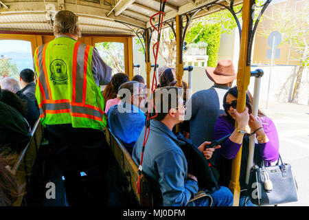 SAN FRANCISCO - Apr 2, 2018: Pendler, eine Seilbahn mit dem Operator oder gripman Steuerung seiner Abstieg Hyde St in Fisherman's Wharf. Ein Stockfoto