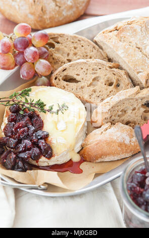 Baked Brie mit Preiselbeeren und frischem Roggenbrot Stockfoto