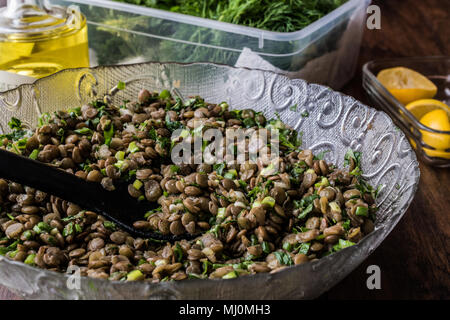 Linsensalat in eine Glasschüssel auf einer hölzernen Oberfläche. Stockfoto
