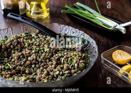 Linsensalat in eine Glasschüssel auf einer hölzernen Oberfläche. Stockfoto