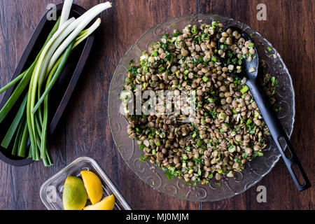 Linsensalat in eine Glasschüssel auf einer hölzernen Oberfläche. Stockfoto