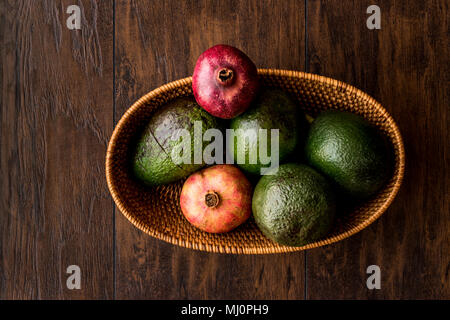 Granatapfel und Avocado in einem hölzernen Warenkorb (Bio-Konzept) Stockfoto