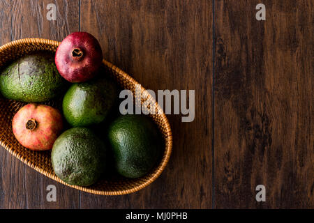 Granatapfel und Avocado in einem hölzernen Warenkorb (Bio-Konzept) Stockfoto