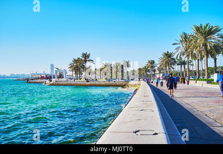 DOHA, Katar - Februar 13, 2018: Der Spaziergang entlang der West Bay mit Blick auf grüne Palmen von lokalen Park, am 13. Februar in Doha. Stockfoto