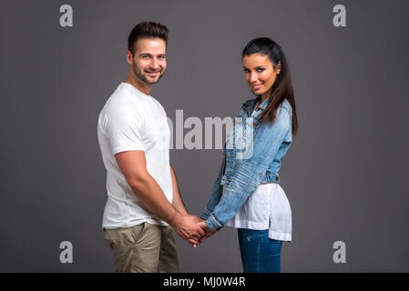 Ein schönes junges Paar von Angesicht zu Angesicht stehen und halten einander die Hände Stockfoto